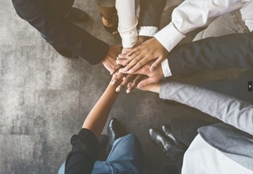 grupo de personas poniendo las manos al centro