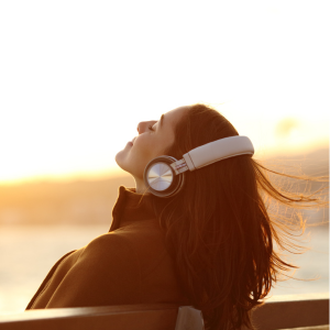 chica sentada en un banco con cascos de música